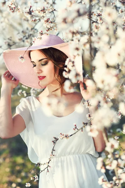 Portret van een jonge vrouw in de bloemrijke tuin in het voorjaar tim — Stockfoto