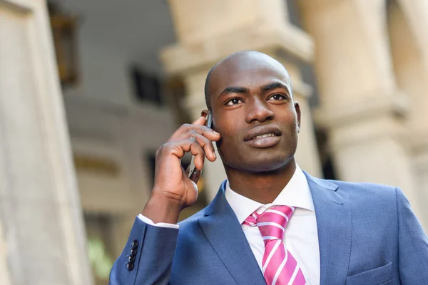 Černá podnikatel hovoří s jeho chytrý telefon v městských poz — Stock fotografie