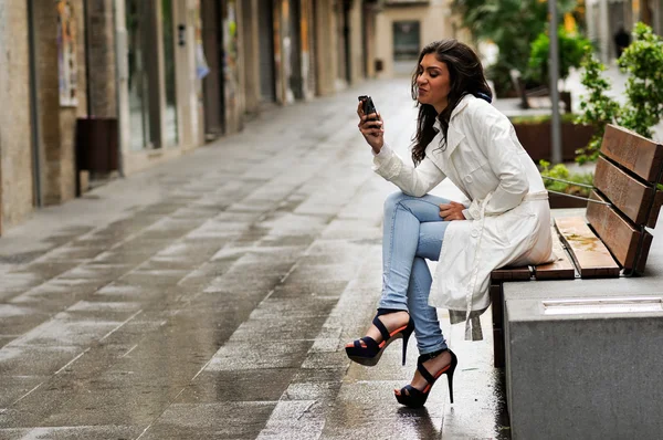 Hermosa joven en el fondo urbano hablando por teléfono — Foto de Stock