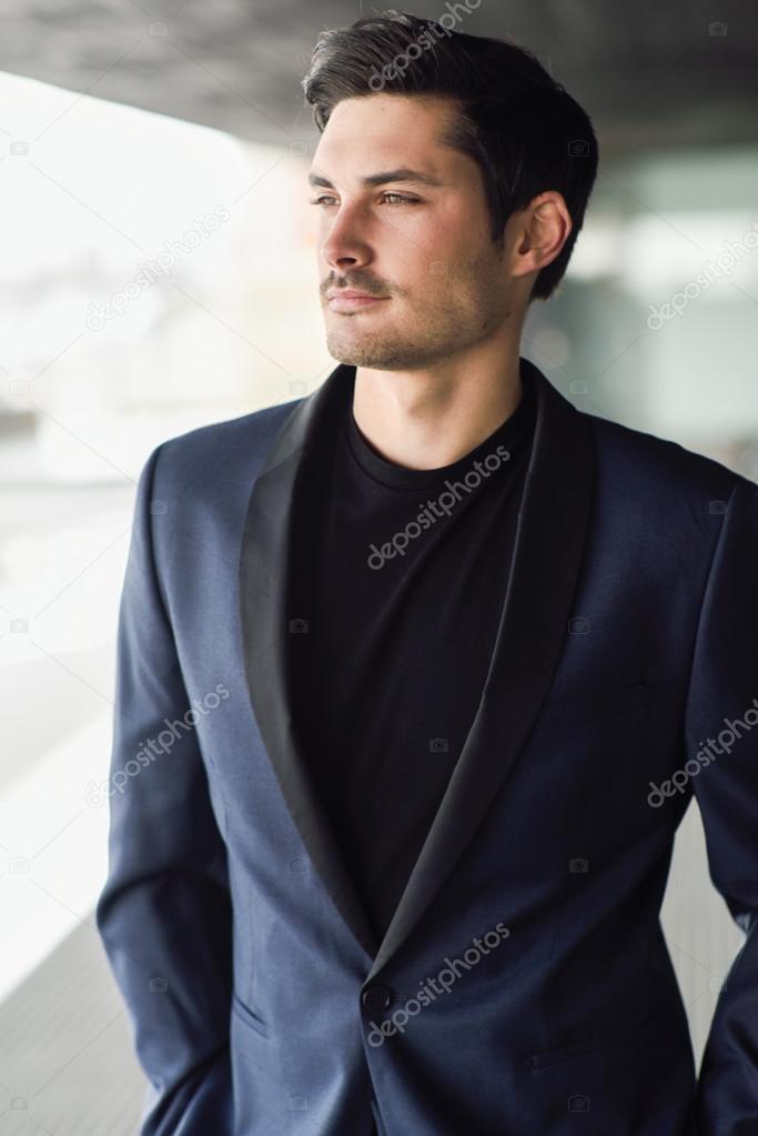 Attractive young businessman in urban background