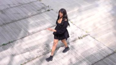 Sokakta dans eden genç siyahi kadın, çok gösterişli kıyafetler giyiyor. Gençlik hayatı ve iyi titreşimler kavramı.