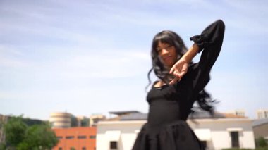 Sokakta dans eden genç siyahi kadın, çok gösterişli kıyafetler giyiyor. Gençlik hayatı ve iyi titreşimler kavramı.