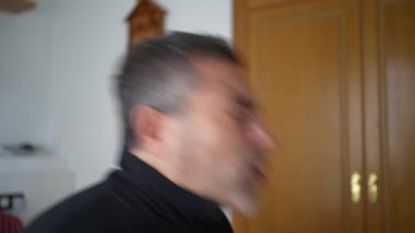 Kapalı alandaki bir adam, hapşırma ve soğuk algınlığından kaynaklanan öksürük ve öksürük sorunlarını sergiler. Rahatlık için tasarlanmış bir yerde, kendini kötü hissetmenin duygusal ve fiziksel bilançosunu vurgular.