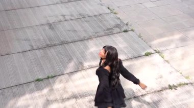 Sokakta dans eden genç siyahi kadın, çok gösterişli kıyafetler giyiyor. Gençlik hayatı ve iyi titreşimler kavramı.