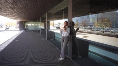 Bir kişi çarpıcı, modern yansıtıcı bir binaya karşı durarak sanatsal zemin modelleri ve izleyicileri büyüleyen parlak çağdaş mimariyi gözler önüne serer.