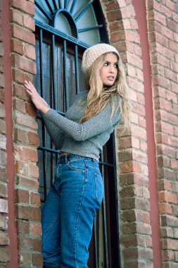 Kentsel arka planda gülümseyen rahat kıyafetler giyen genç kadın