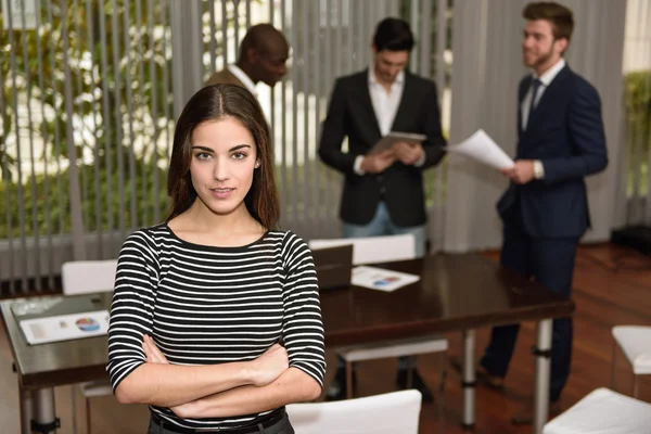 Geschäftsfrau mit verschränkten Armen im Arbeitsumfeld — Stockfoto