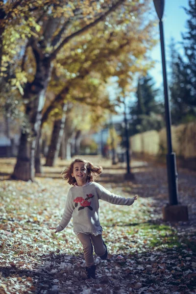 Sonbaharda bir şehir parkında oynayan küçük kız — Stok fotoğraf