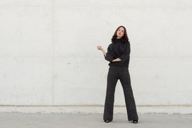 Kentsel arka planda rahat kıyafetler giyen genç kadın