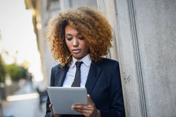 Czarna kobieta przy użyciu komputera typu tablet w mieście — Zdjęcie stockowe