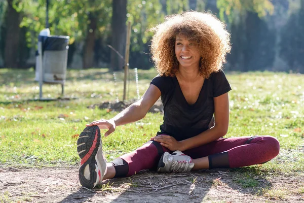 Fitness siyah kadın runner çalıştırdıktan sonra bacak germe — Stok fotoğraf