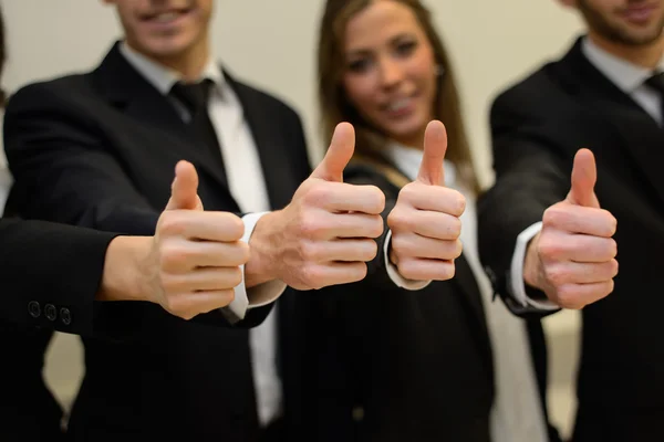 Equipe de negócios segurando seus polegares — Fotografia de Stock