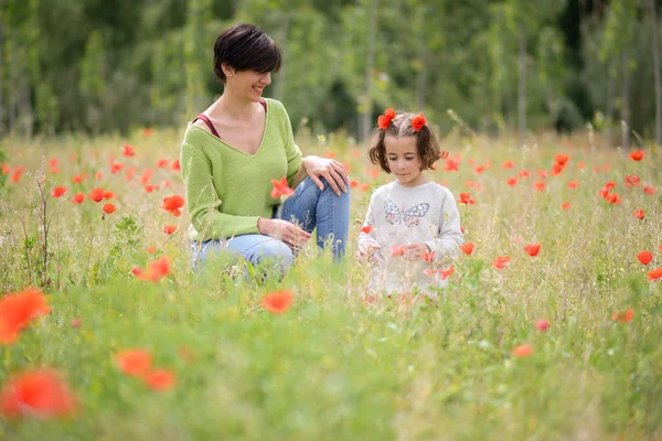 Мать со своей маленькой дочерью на маковом поле — стоковое фото