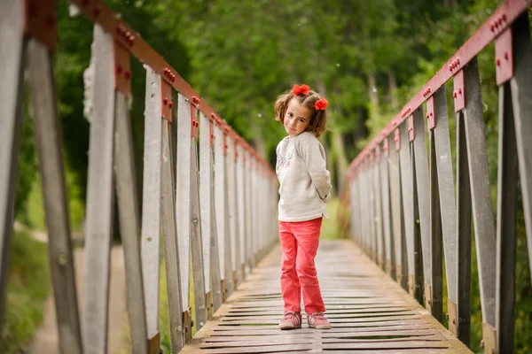 Menina bonito se divertindo em uma ponte rural — Fotografia de Stock