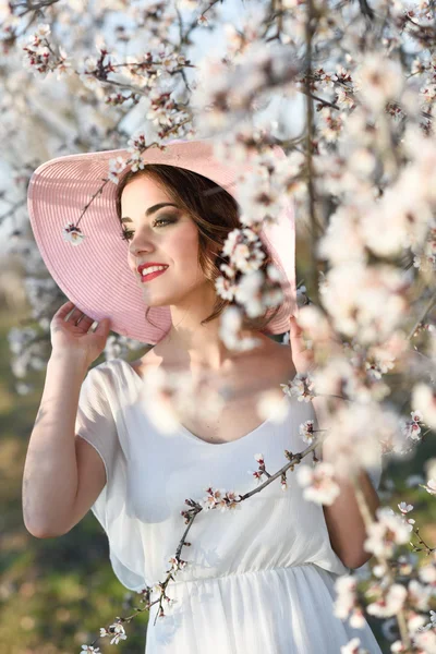 Portret van een jonge vrouw in de bloemrijke tuin in het voorjaar tim — Stockfoto