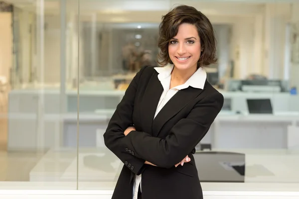Business woman in an office. Crossed arms — Stock Photo, Image