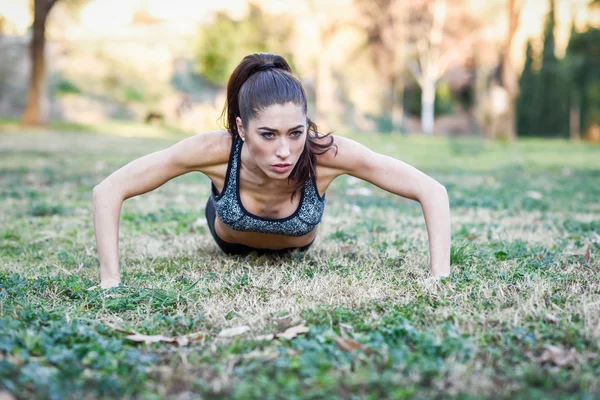 Fitness dívka dělat kliky venku — Stock fotografie