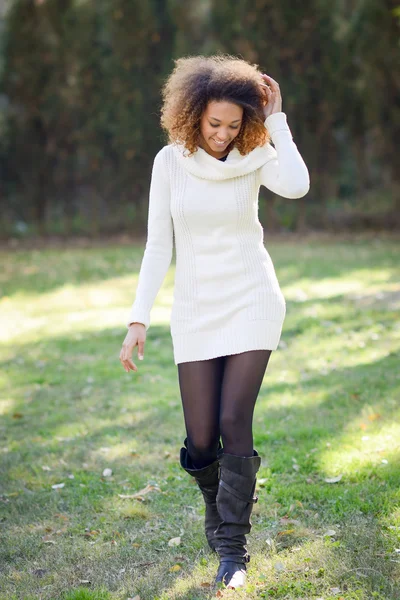 Chica joven con peinado afro caminando en un parque urbano —  Fotos de Stock