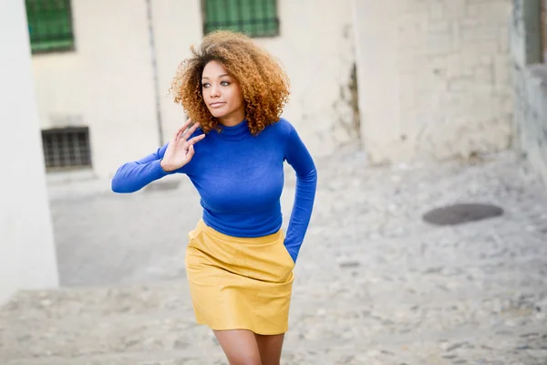Giovane ragazza con acconciatura afro in background urbano — Foto Stock