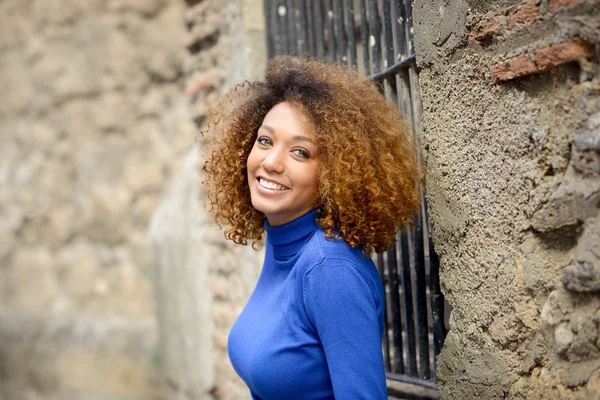 Ung flicka med afro frisyr i urban bakgrund — Stockfoto