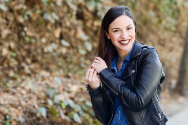 Kentsel arka planda rahat kıyafetler giyen genç kadın