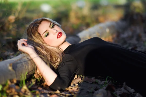 Relaxed girl lying on the field with long curly hair. — Stock Photo, Image