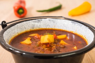 Macar Biftek Gulaş 'ı veya Gulyas Çorbası veya Güveç Patates, Et, Paprika, Bell Pepper ve Chili ile küçük bir kazanda servis edilir.