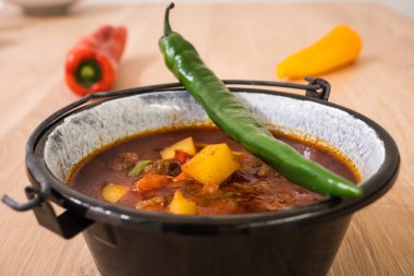 Macar Biftek Gulaş 'ı veya Gulyas Çorbası veya Güveç Patates, Et, Paprika, Chili ve Bell Pepper ile küçük bir kazanda servis edilir.