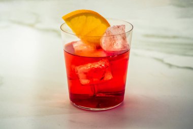 Campari Soda Aperitivo Kokteyl Öncesi Akşam Yemeği İçeceği Kayalıklarda Portakal Dilimleyici ile süslenmiş..