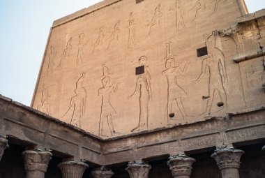 Edfu Tapınağı - Büyük Pylon 'un kuzey cephesi Kral XII. Ptolemy' nin kurtarıcılarıyla Horus ve Hathor ile etkileşim halindedir..