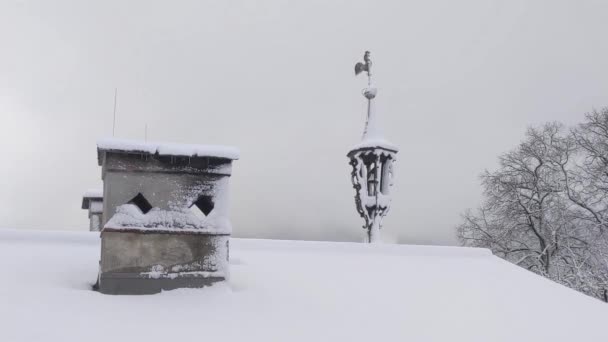 雪に覆われた屋根で冬には 伝統的な煙突と天気のコックや天気のベーンとグロズロックナーストラスを破っ — ストック動画