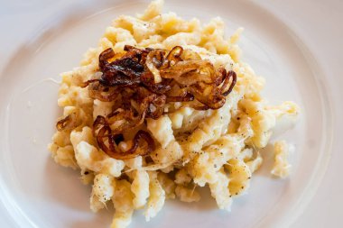 Tirol Peynirli Erişte ya da Makarna adı Kaesespaetzle ile Kızarmış Soğanlı Beyaz Tabak, Tipik ve Geleneksel Avusturya Tabağı