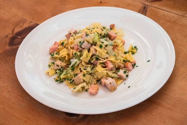 Krautfleckerl, Avusturya makarnası karamelize edilmiş lahana ile rostolu ahşap bir masa üzerinde domuz rostosu.