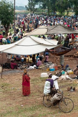 Kasese, Uganda - 22 Temmuz 2011: Afrika 'da yerel, kırsal bir pazarda kalabalık. Siyahi Kadın ve Erkekler Alışveriş, Alışveriş ve Alışveriş, Bisikletle Taşımacılık..