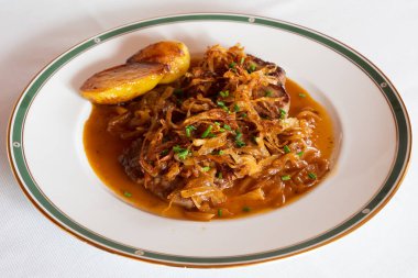 Viyana usulü Zwiebelrostbraten, soğan soslu sığır filetosu, kızarmış soğan ve kızarmış patates.