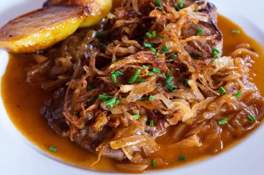 Viyana usulü Zwiebelrostbraten, soğan soslu sığır filetosu, kızarmış soğan ve kızarmış patates.