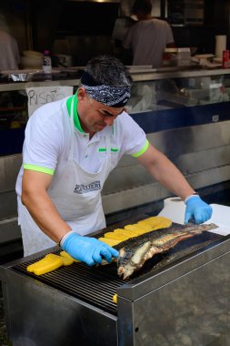 Comacchio, İtalya - 28 Eylül 2025: Man Grilling Eel ve Polenta Sagra del Anguilla Yılanbalığı Festivali 'nde.