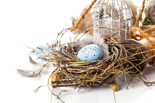 Пасхальные яйца гнездо с клеткой для птиц, на белом деревянном фоне — стоковое фото