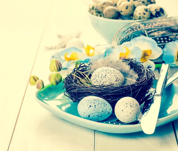Beyaz ahşap plaka üzerinde yuva masa dekorasyonu ile Paskalya yumurta — Stok fotoğraf