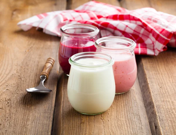 Healthy yougurt in a glass jars on wooden background — Stock Photo, Image
