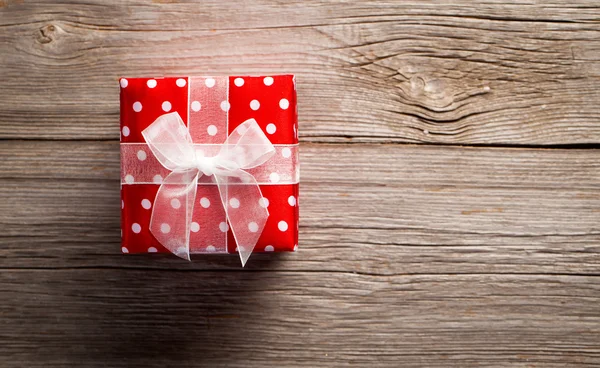 Red gift on a wooden background — Stock Photo, Image