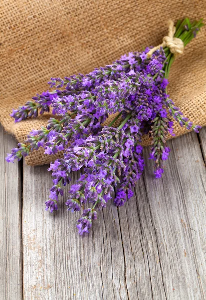 Lavendel in een mand met jute op de houten pagina — Stockfoto