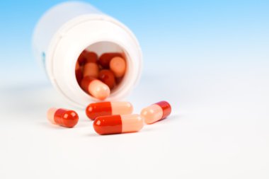 hap hap şişesi izole (ile örnek mavi üzerinde dışarı dökülmesini 