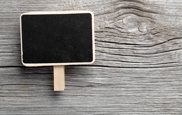 Vintage slate chalk board hanging on wooden background — Stock Photo, Image