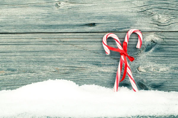 Барвисті смугасті червоні та білі різдвяні цукерки з зимовим снігом — стокове фото