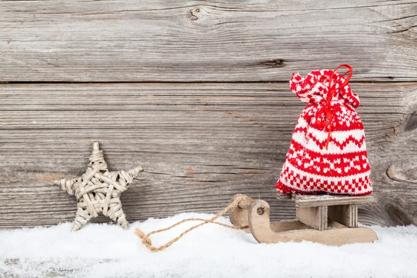 Рождественские украшения на снегу, деревянный фон — стоковое фото