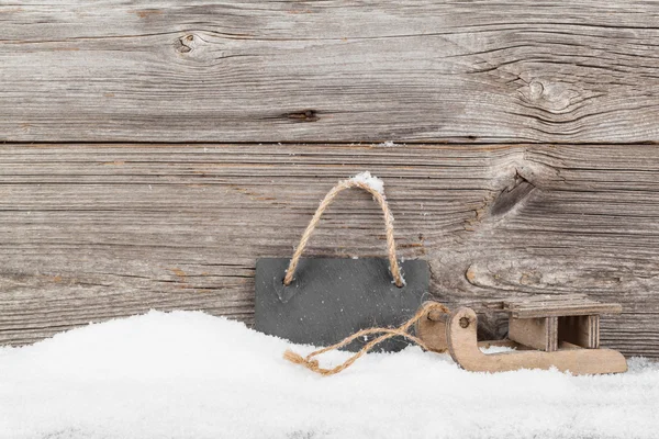 Oude rustieke houten sledge, over sneeuw, houten achtergrond — Stockfoto