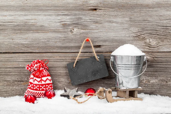 Χιόνι σε έναν κάδο σε ένα έλκηθρο, σε ξύλινο φόντο, με τα Χριστούγεννα — Φωτογραφία Αρχείου