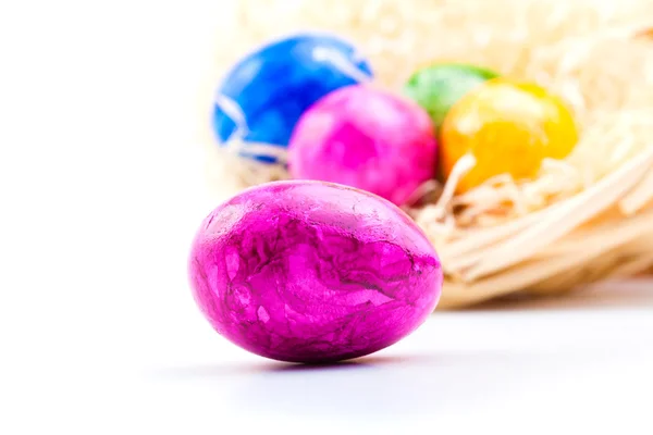 Close up of colorful easter eggs in basket, on white background — Stock Photo, Image