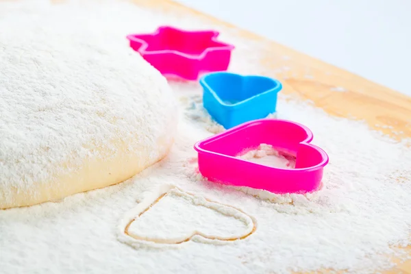 Heart shaped cookie cutter on flour — Stock Photo, Image